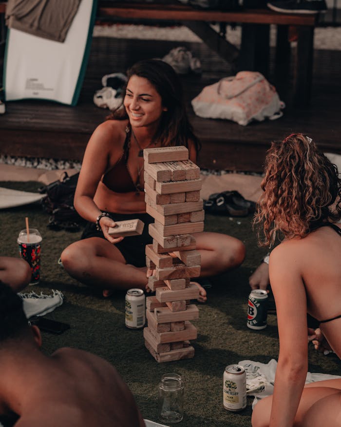 Group of friends playing Jenga outdoors, having fun during a summer vacation in Australia.